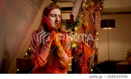 Scared woman calling 911 emergency for police or ambulance to come on Christmas night. Crime, ambulance, injury, problems with law and theft on winter holidays and celebrations. 108930506