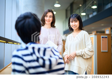 図書室で話す男女の大学生 撮影協力：有明教育芸術短期大学 108932243