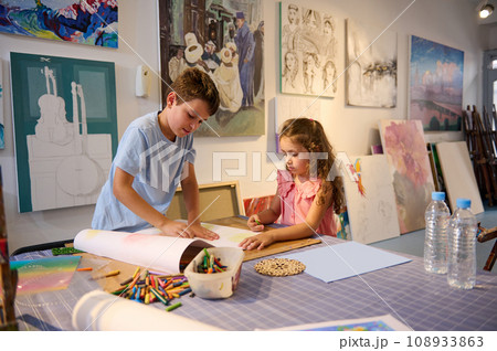 Two Caucasian adorable inspired children learning art, drawing with pencils in creative workshop. Elementary age school. 108933863