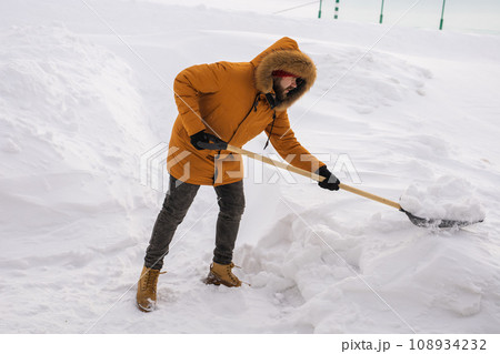 Man cleaning snow from sidewalk and using snow shovel. Winter season Man cleaning snow from sidewalk and using snow shovel. Winter season 108934232