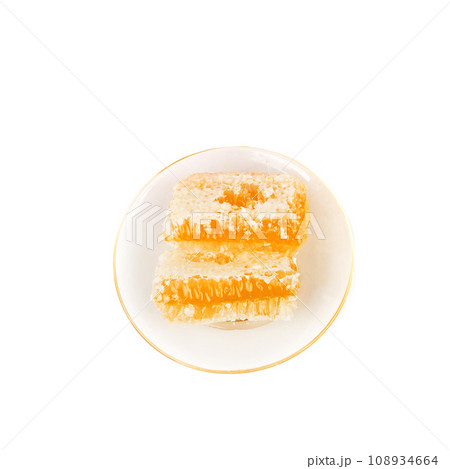 Honey in a comb isolated on a white background. Honey in a comb isolated on a white background. 108934664