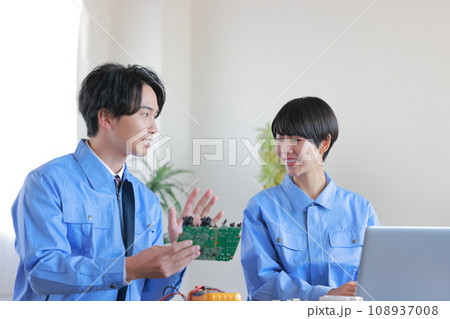 基板について女性に解説する男性エンジニア1 108937008