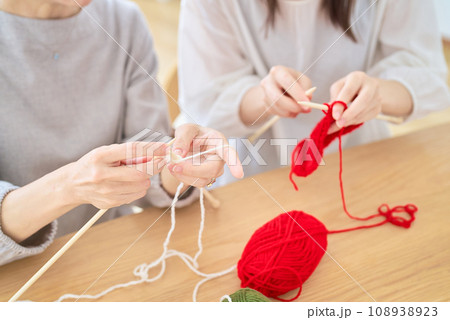 編み物をするシニア女性と若い女性の手元 108938923
