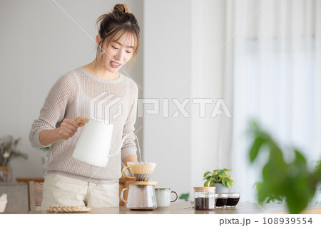部屋でコーヒーを入れる女性 108939554