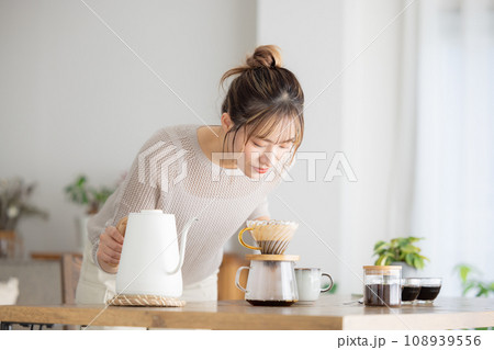 部屋でコーヒーを入れる女性 108939556