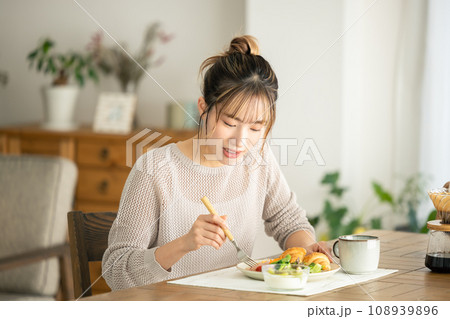 自宅で食事をとる女性 108939896