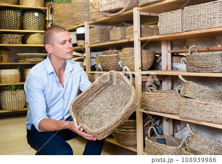 Man choosing wicker basket in store 108939986