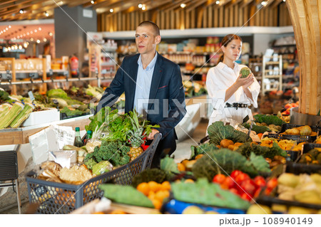 Man with shopping cart choosing groceries 108940149