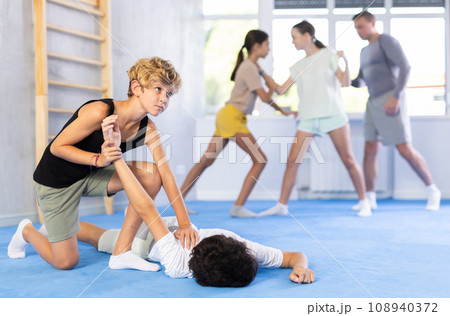 Girls and boys adolescents of performing protection with wring hands during training in self-defense 108940372