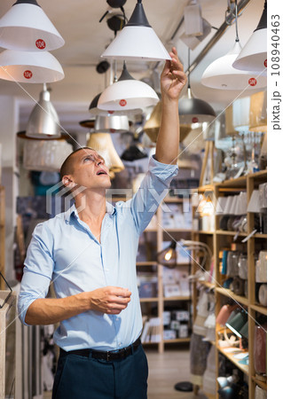Man choosing ceiling lamp Man choosing ceiling lamp 108940463
