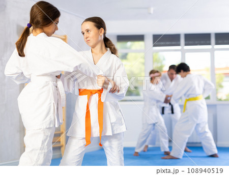 Children athletes in pair conduct training battle in oriental fighting technique Children athletes in pair conduct training battle in oriental fighting technique 108940519