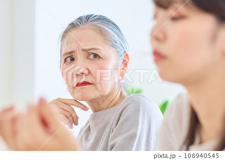 若い女性を険しい表情で見るシニア女性 108940545