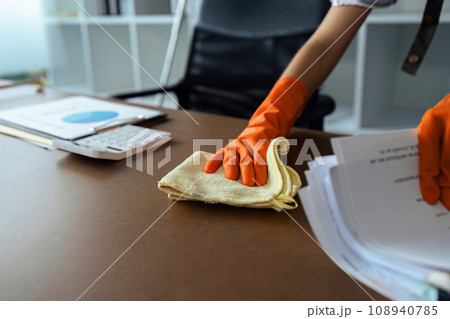Woman maid cleaning and wiping the table with microfiber cloth in office Woman maid cleaning and wiping the table with microfiber cloth in office 108940785