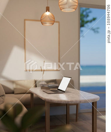 Comfortable cozy minimal living room with beige sofa and coffee table near large window with laptop computer. 108944706