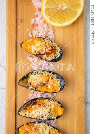 oysters scallops with red sea salt and citric acid on a wooden tray 108945413