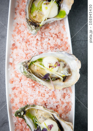 Grilled oysters on red sea salt with lime Grilled oysters on red sea salt with lime 108945430