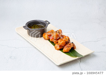 Slices of pike perch in sweet and sour sauce on a banana leaf 108945477