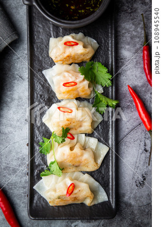 steamed dumplings with herbs, chili and soy sauce 108945540