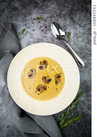 mushroom cream soup with herbs and champignons in a white plate mushroom cream soup with herbs and champignons in a white plate 108945541