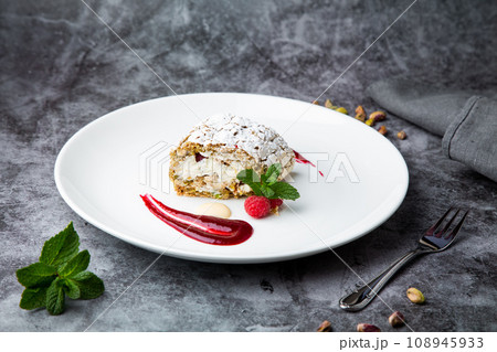 sweet sponge dessert with raspberries and powdered sugar side view 108945933
