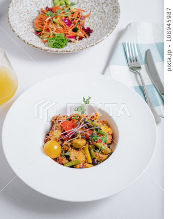vegetable stew with potatoes, tomatoes and herbs with sauce in a deep plate side view 108945987