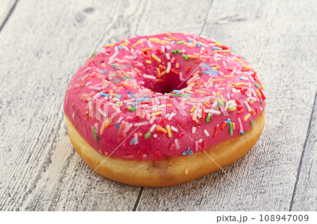 Sweet glazed struwberry donut with icing 108947009