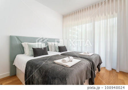 Double bed in the bright bedroom room interior furnishing furniture.With a black blanket and towels on a roll and fragrant grass. 108948024