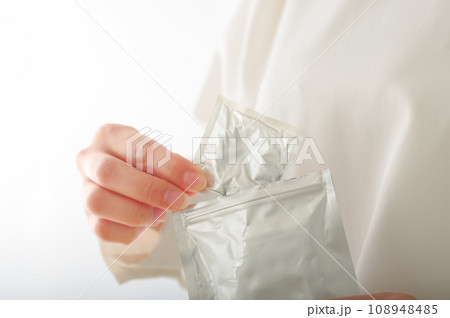 コンドームを手渡す女性の手元 108948485