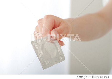 コンドームを手渡す女性の手元 108948493