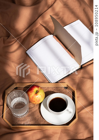 Open empty notebook and coffee cup on bed. Cozy morning at home. 108950214