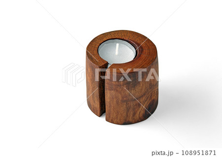 Two candles in wooden candlesticks from a tree trunk with a crack isolated on a white background 108951871