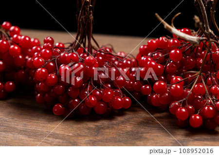 A bunch of ripe viburnum berries on a wood background close-up 108952016