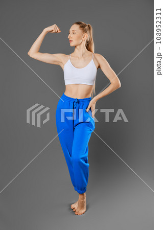 Sportive woman shows biceps muscle Sportive woman shows biceps muscle 108952311