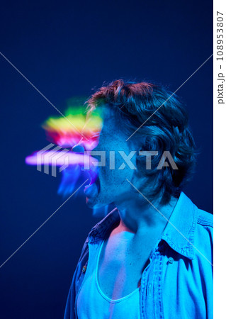 Mood swings. Crazy young man shouting in mixed neon light illuminating futuristic, digital projector reflection. Mood swings. Crazy young man shouting in mixed neon light illuminating futuristic, digital projector reflection. 108953807