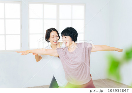 ヨガインストラクターにヨガのレッスンを受けるミドル女性のグループ 108953847