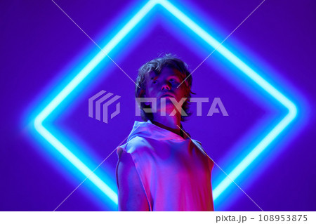 Futuristic portrait of handsome, calm man posing in neon light against background with abstract digital, projector reflection. Futuristic portrait of handsome, calm man posing in neon light against background with abstract digital, projector reflection. 108953875
