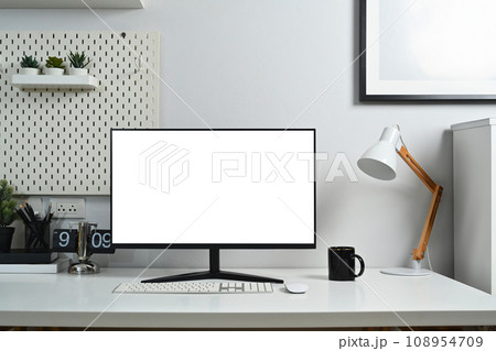 Home office workplace with blank computer screen, coffee cup and stationery against white wall Home office workplace with blank computer screen, coffee cup and stationery against white wall 108954709