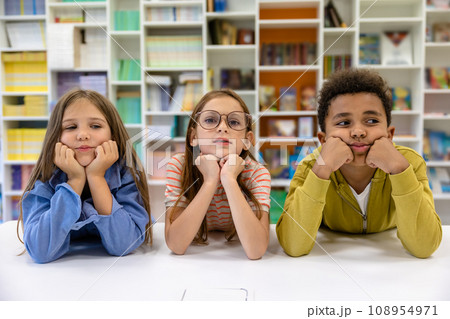 Classmates pupils posing in library or classroom. Classmates pupils posing in library or classroom. 108954971