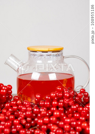 Hot viburnum tea in a teapot on a white background. Hot viburnum tea in a teapot on a white background. 108955186