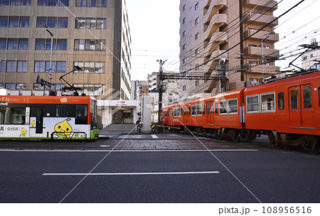 路面電車と道路を横切る列車 108956516