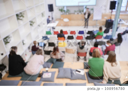 Male speaker at a conference, seminar, lecture. Personal growth training or business training. People's faces are not visible in the photo. Blurred. High quality photo 108956780