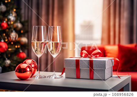 Two glasses of champagne and christmas decoration on the table in the room. Selective focus Two glasses of champagne and christmas decoration on the table in the room. Selective focus 108956826