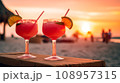 Two watermelon sex on the beach glasses of cocktail with lime slice on blur beach with sunset, sky and palm on background.  108957315