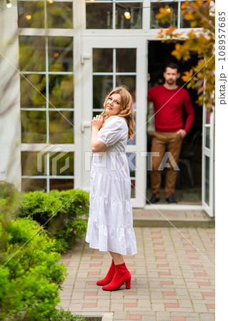 A man and a woman in the courtyard of a country house. 108957685