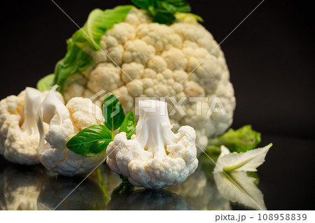 slices of raw small raw cauliflower on black background slices of raw small raw cauliflower on black background 108958839