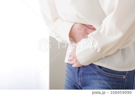 お腹が痛そうに手を当てている女性 お腹が痛そうに手を当てている女性 108959090