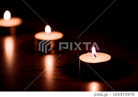 暗闇に浮かぶろうそくの炎 暗闇に浮かぶろうそくの炎 108959976