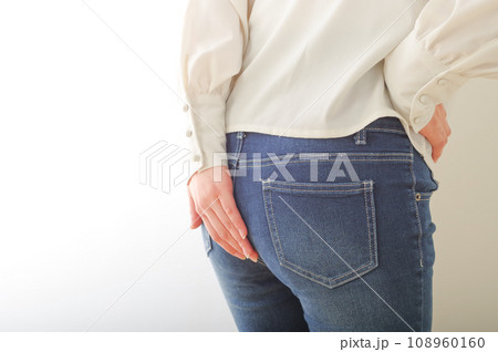 お尻を手で押さえる若い女性 お尻を手で押さえる若い女性 108960160