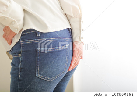 お尻を手で押さえる若い女性 108960162