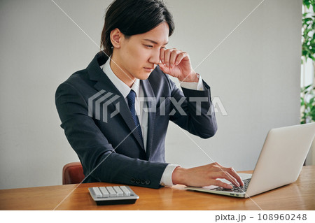 目がかゆくて指でこする若い男性会社員 目がかゆくて指でこする若い男性会社員 108960248
